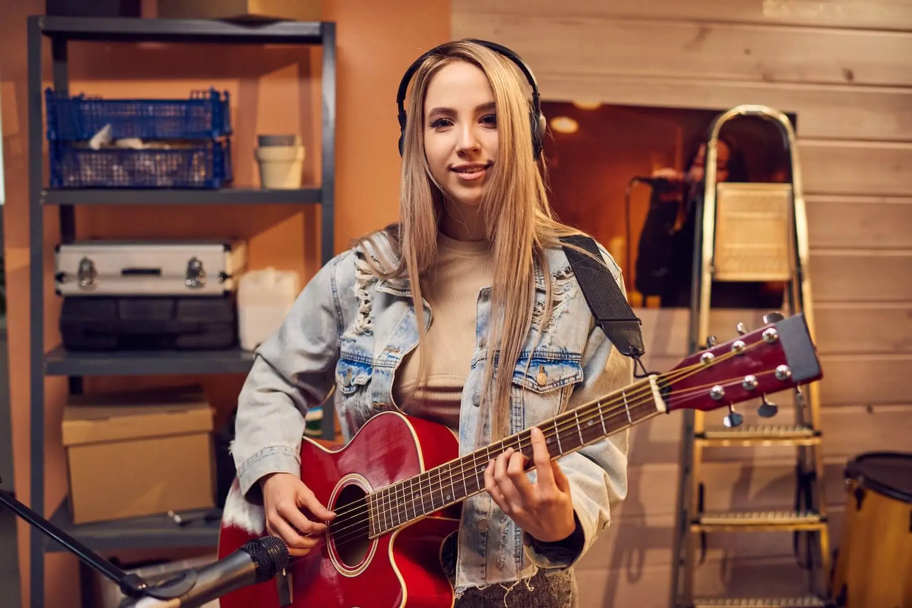 A woman with a red acoustic guitar